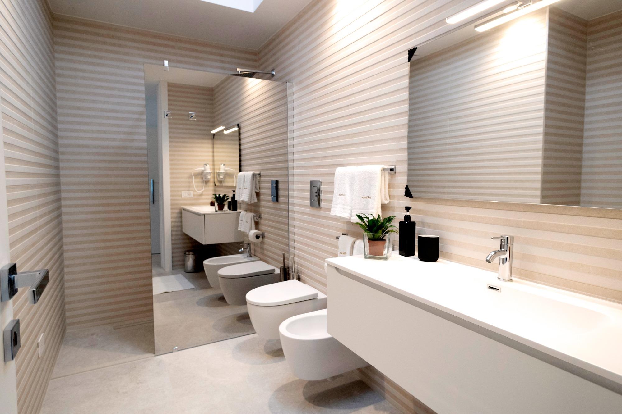Bagno moderno con doccia a filo pavimento, wc, bidet el lavabo.