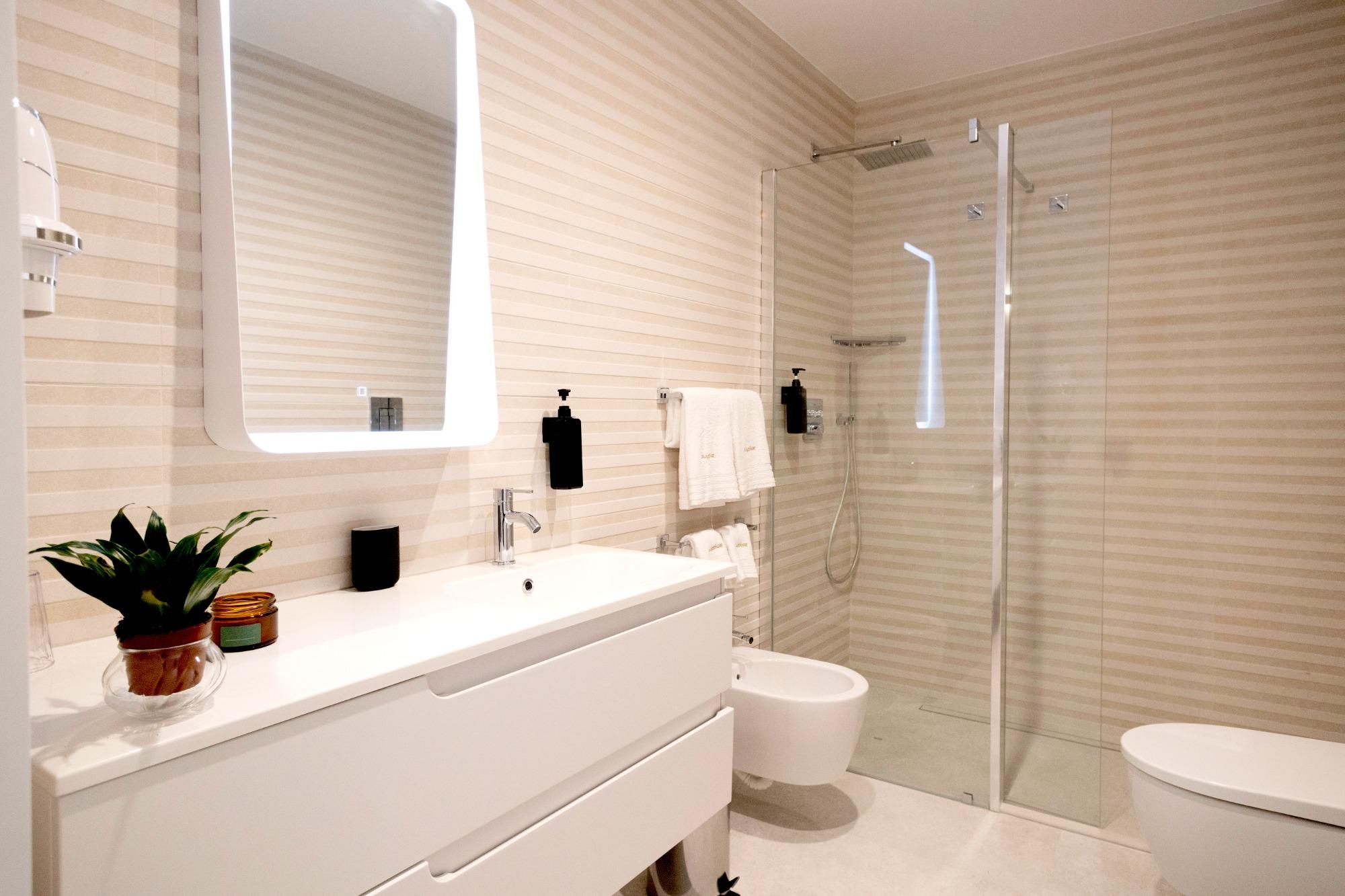 Bagno moderno con doccia a filo pavimento, wc, bidet el lavabo.