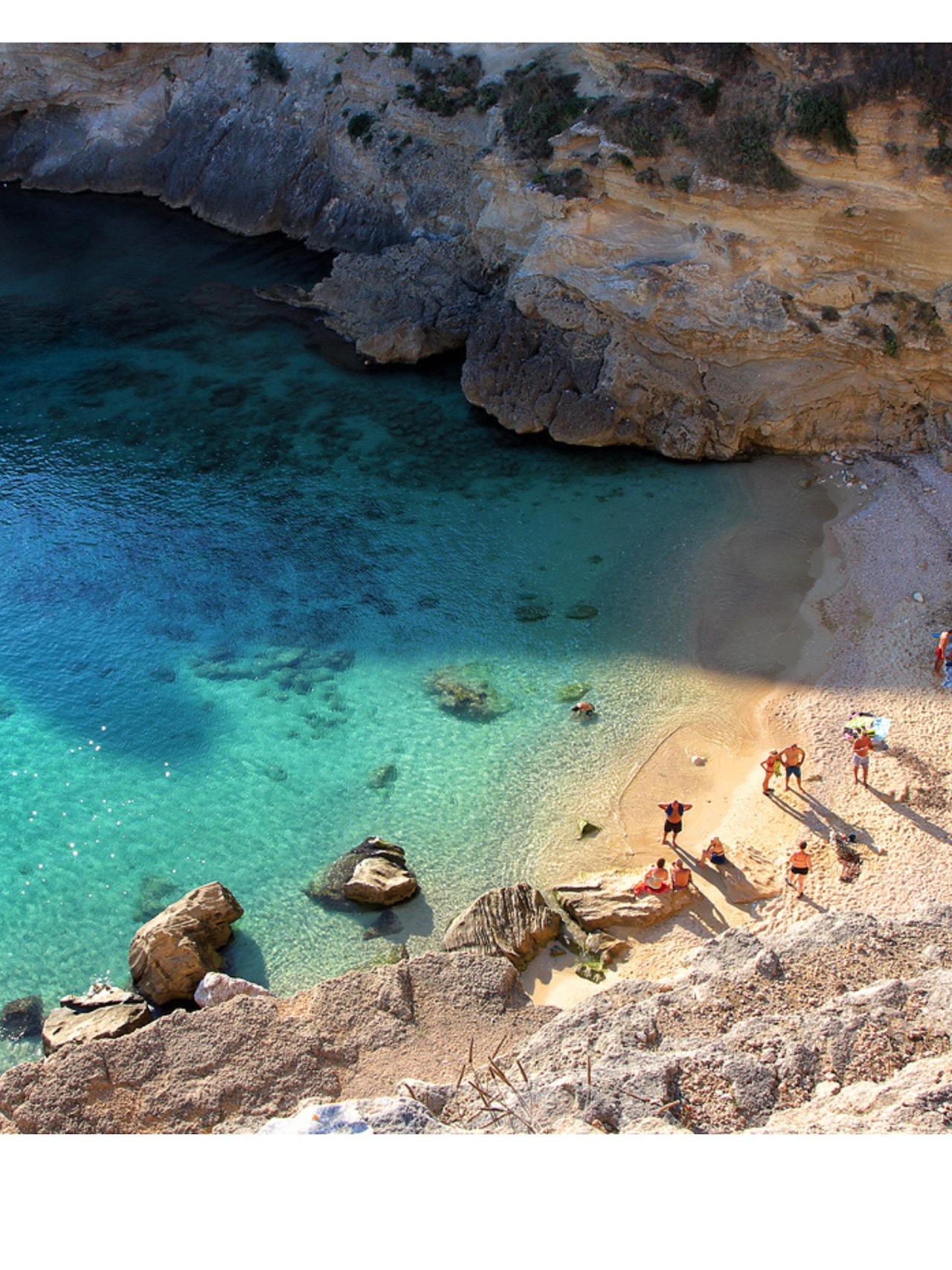 Spiaggia di Porto Miggiano: sabbia e mare turchese incastonati tra alte scogliere.