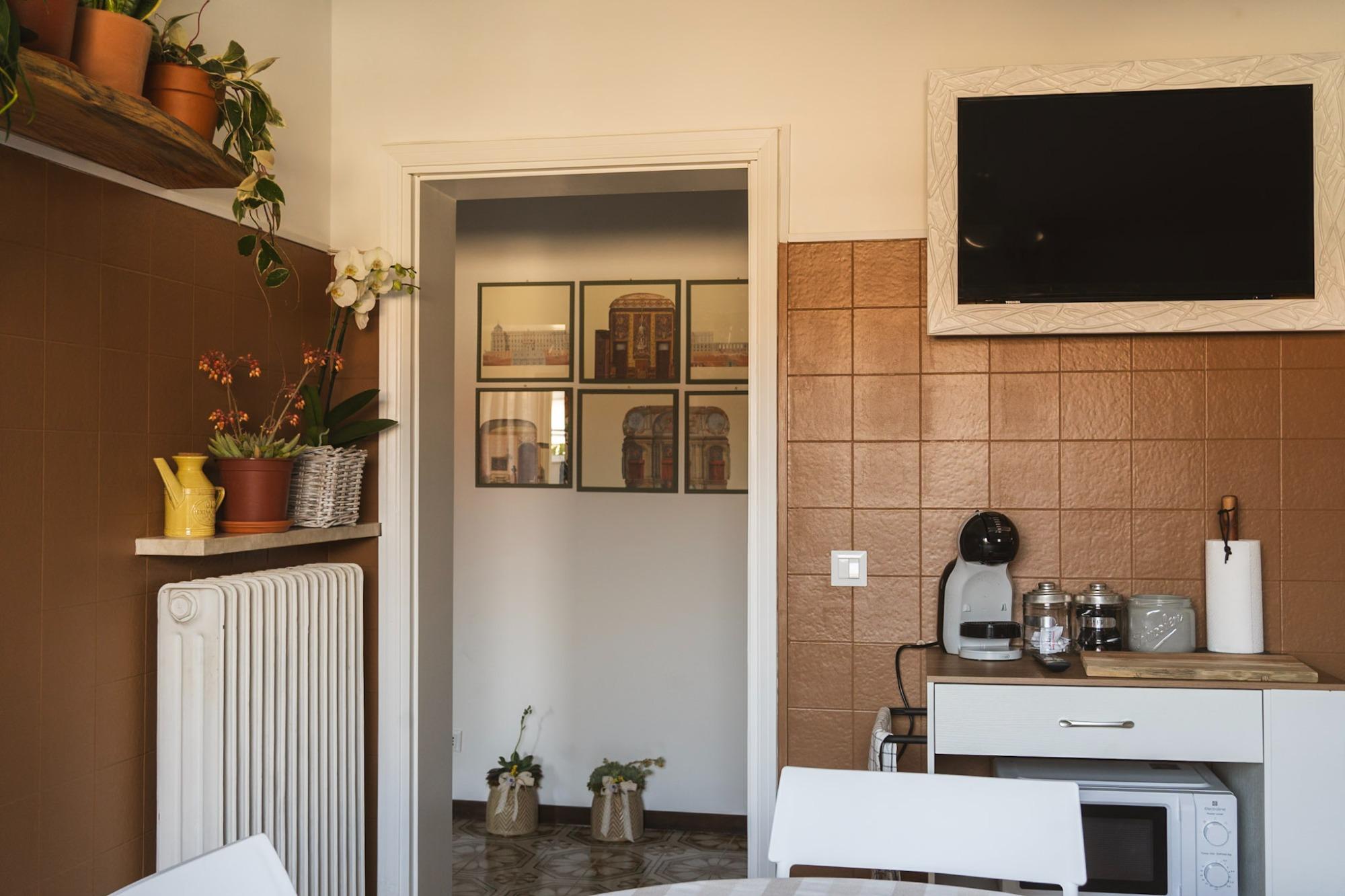 cucina con tavolo, 4 sedie, prodotti lavapiatti, bidoni spazzatura differenziata