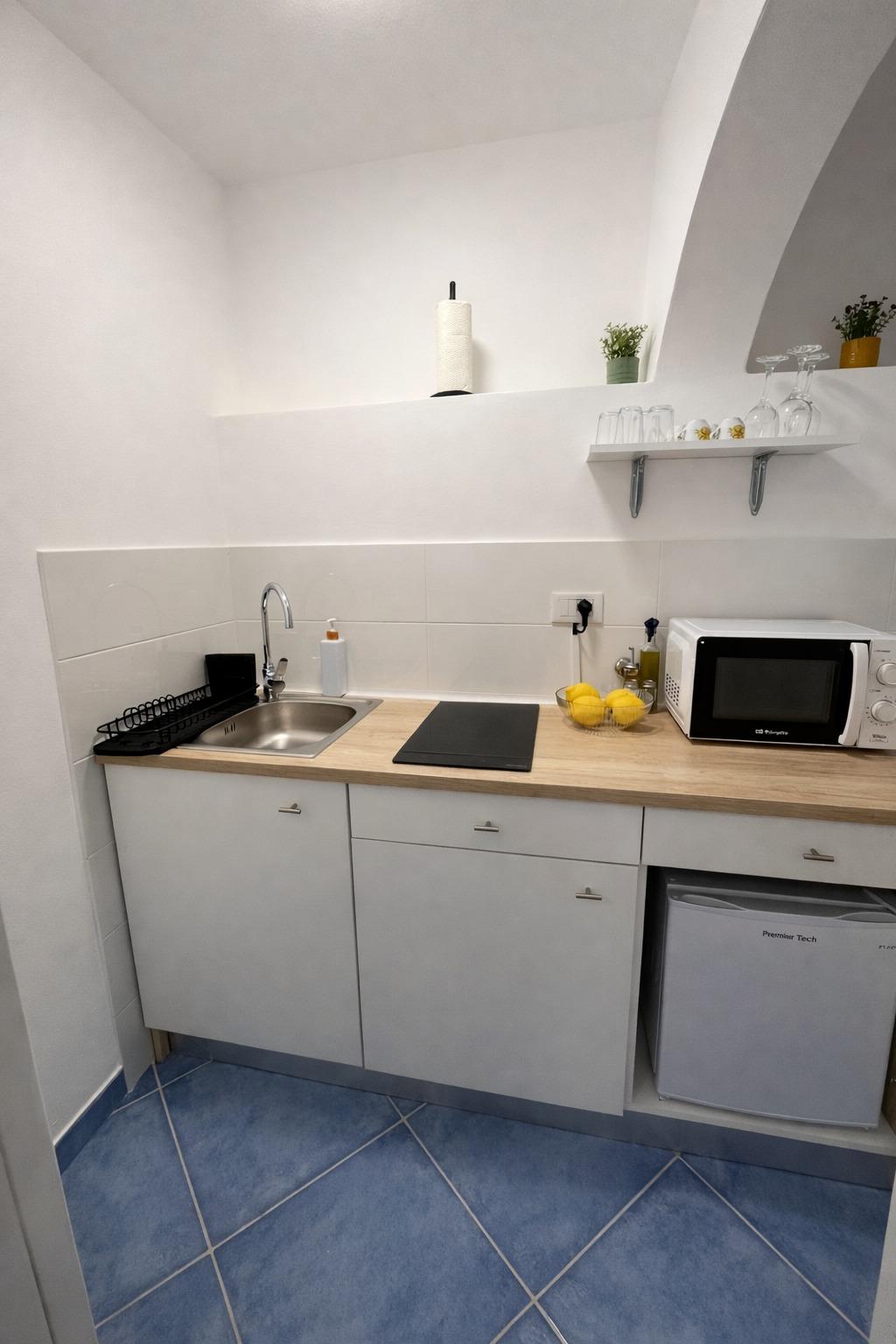 Cucina attrezzata con piano a induzione e frigo, perfetta per soggiorni brevi