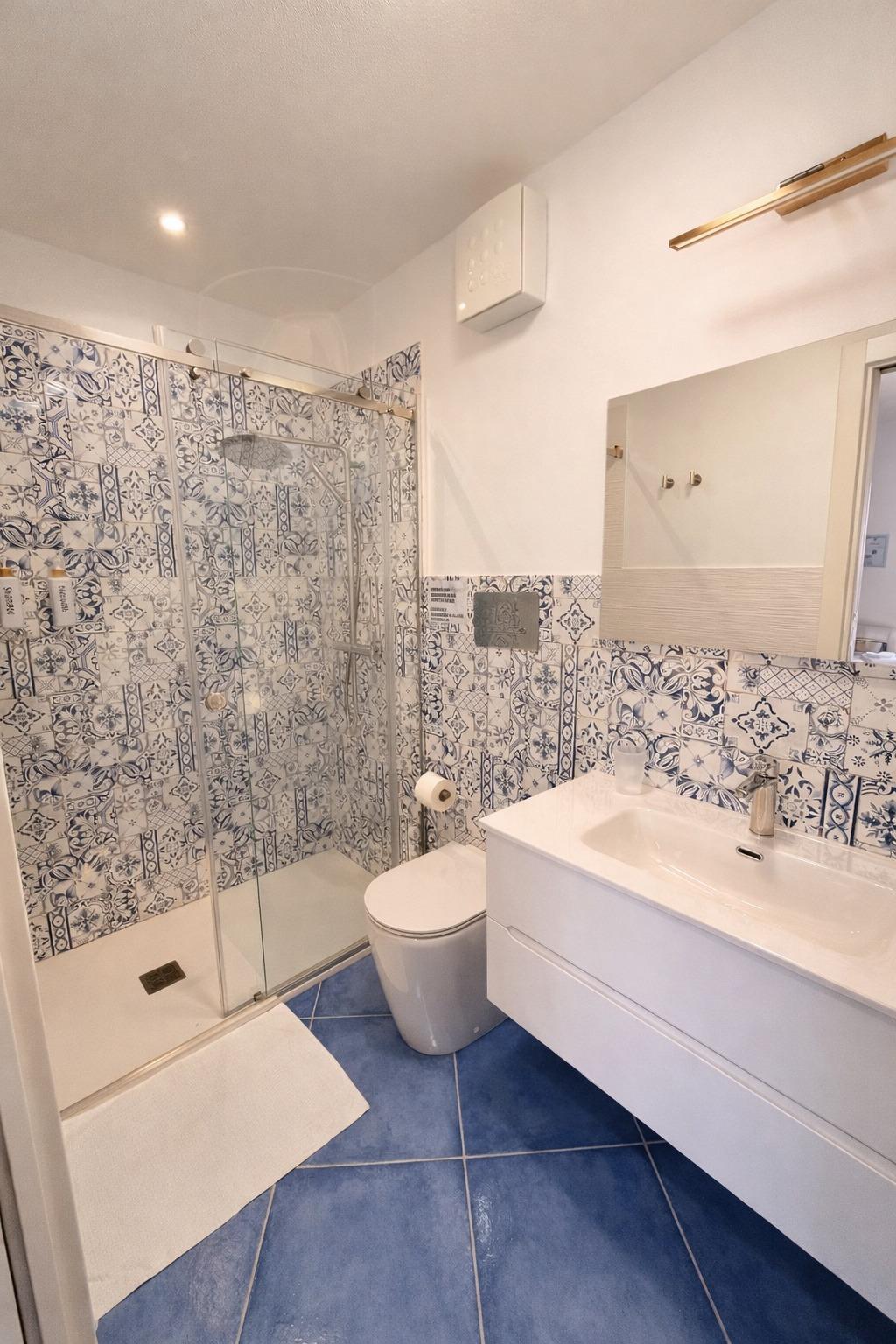 Bagno moderno con maioliche siciliane, dove stile e comfort si incontrano.