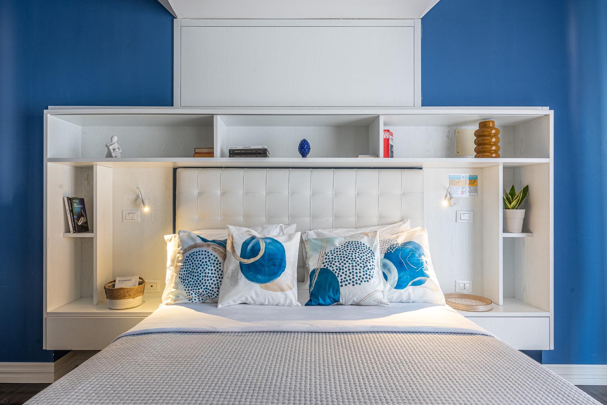 Testata su misura con libreria e morbidi cuscini colorati: a Sunny Suite ogni dettaglio è creato per offrirti un angolo di relax intimo e ricercato