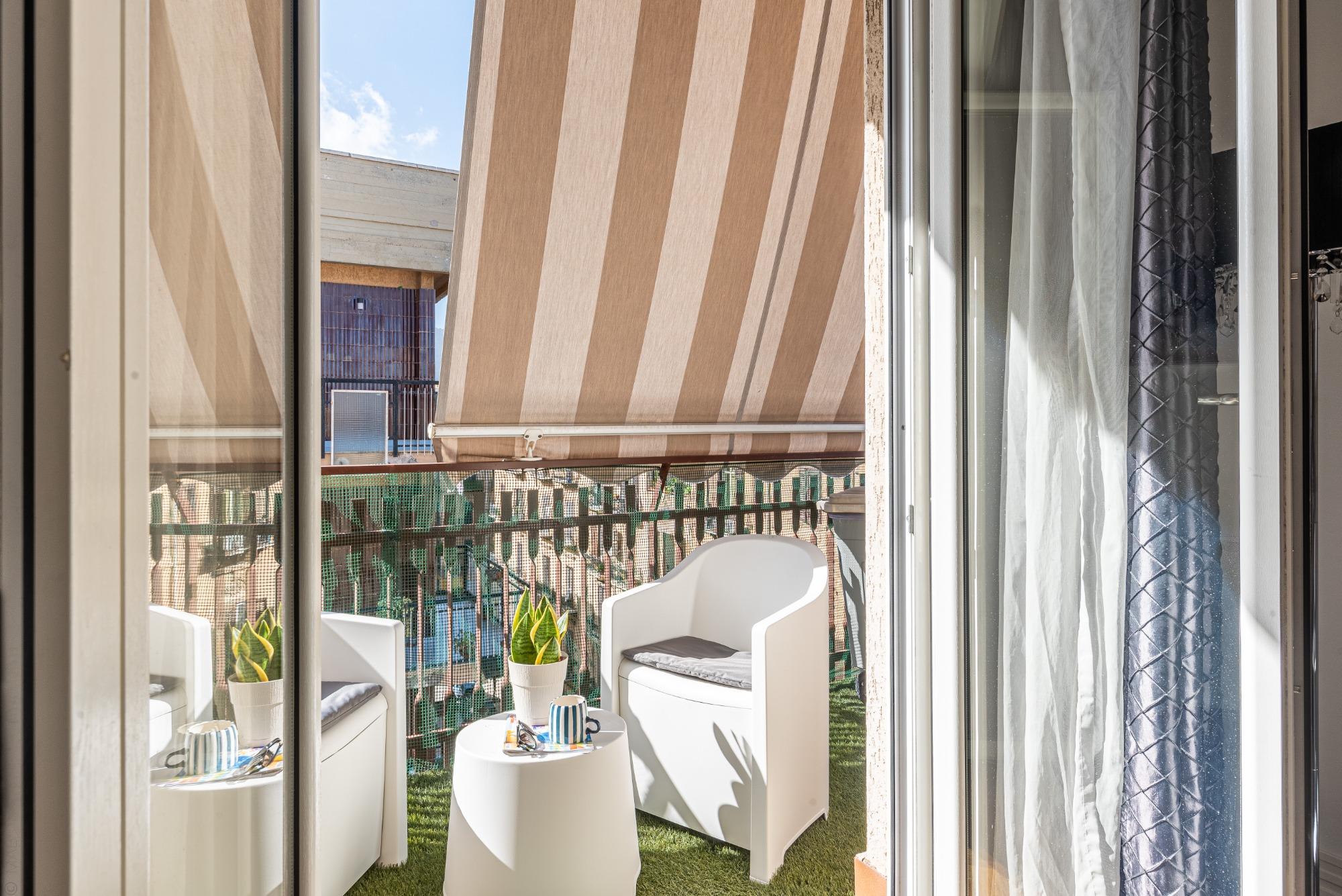 Comfort anche in estate: le tende da sole proteggono il balcone dal caldo, creando l'ombra perfetta per il tuo caffè in totale relax a Sunny Suite.