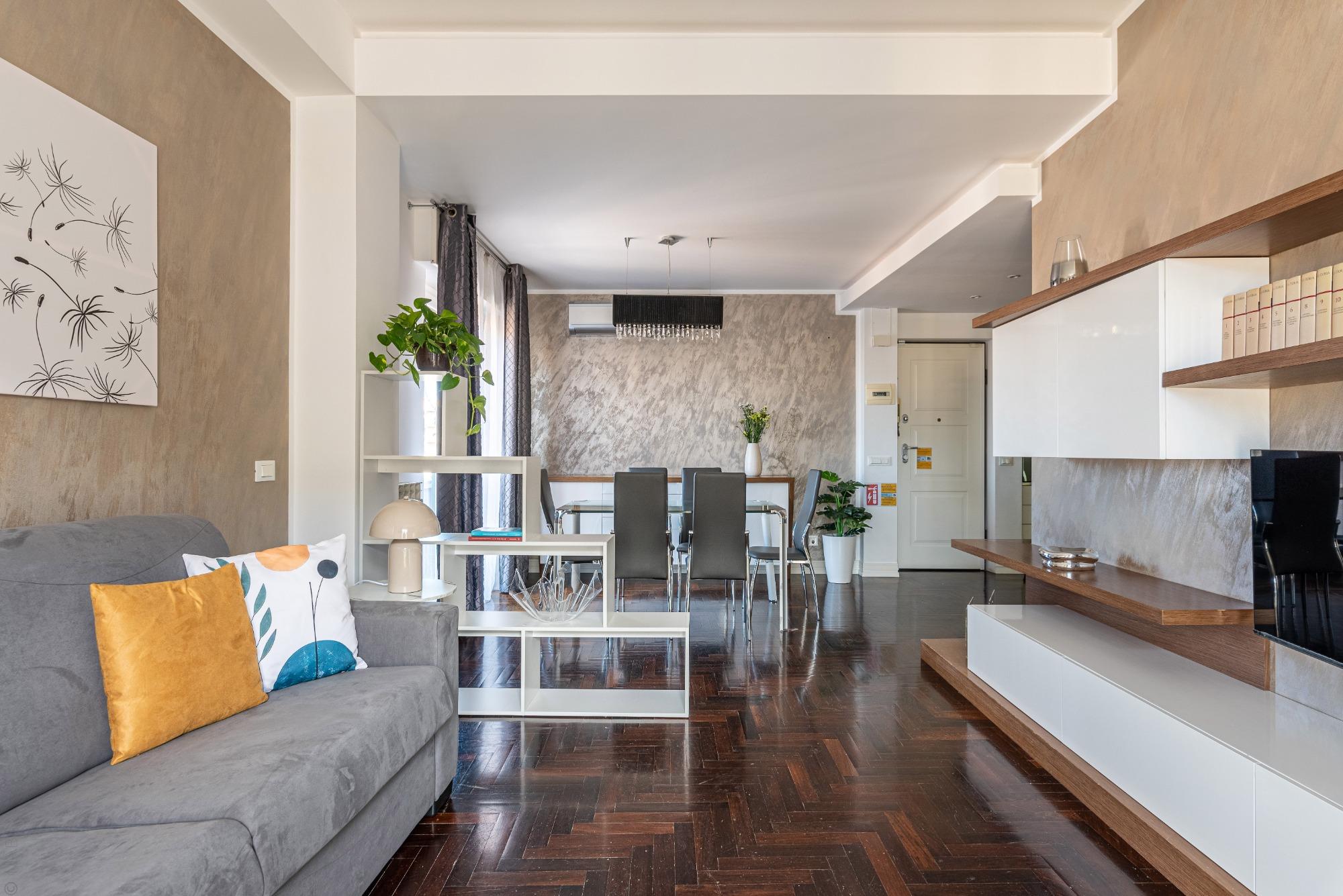 Eleganza naturale: il pregiato parquet in wengé esalta le forme ricercate della parete attrezzata. Una zona living raffinata dove il design incontra i