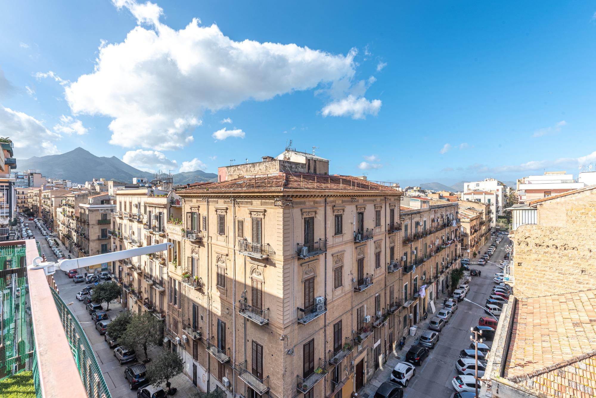 Uno sguardo su Palermo: il balcone angolare offre una vista unica sulle vie della città e sulle maestose montagne circostanti. La bellezza siciliana a