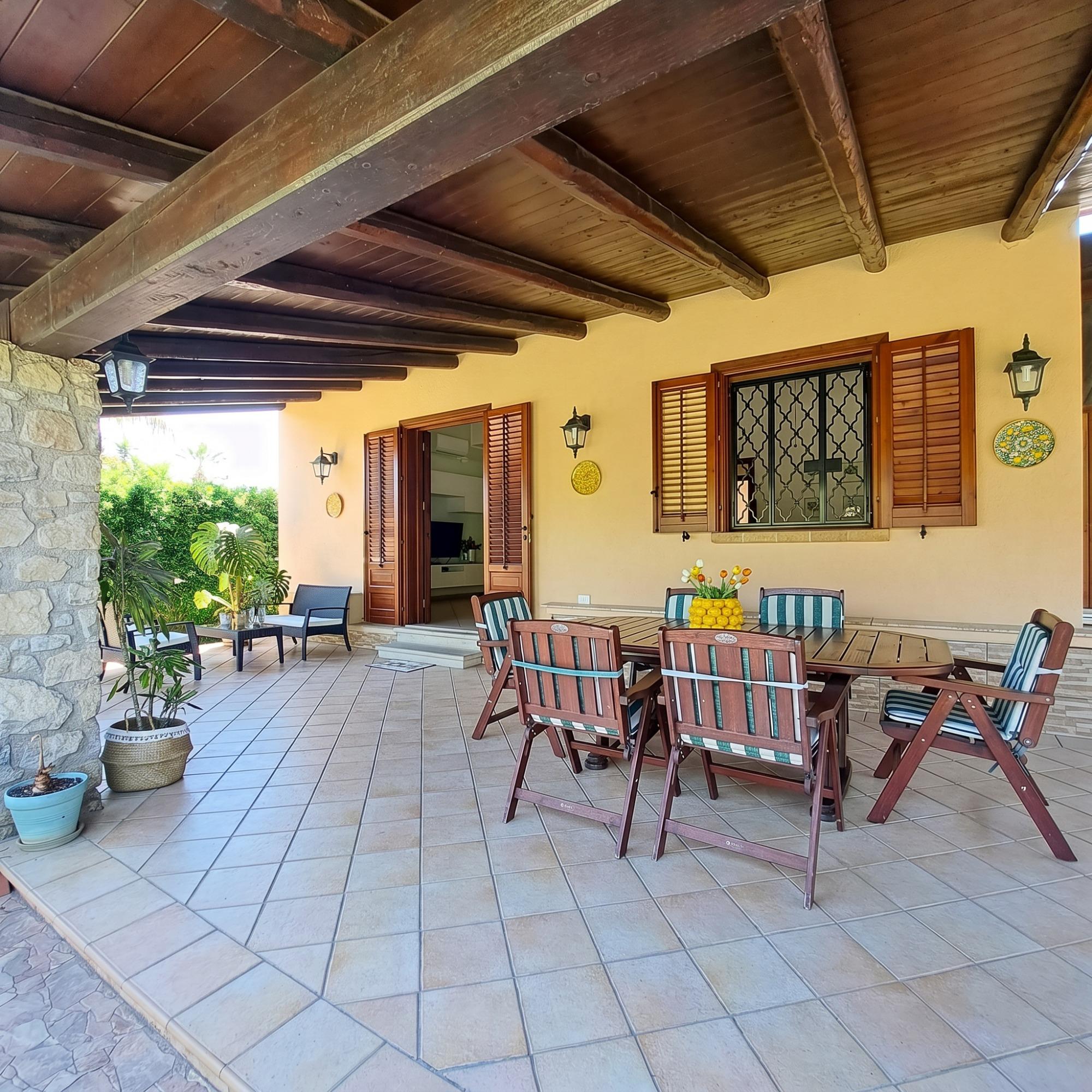 Vista veranda con tavolo da pranzo e salottino