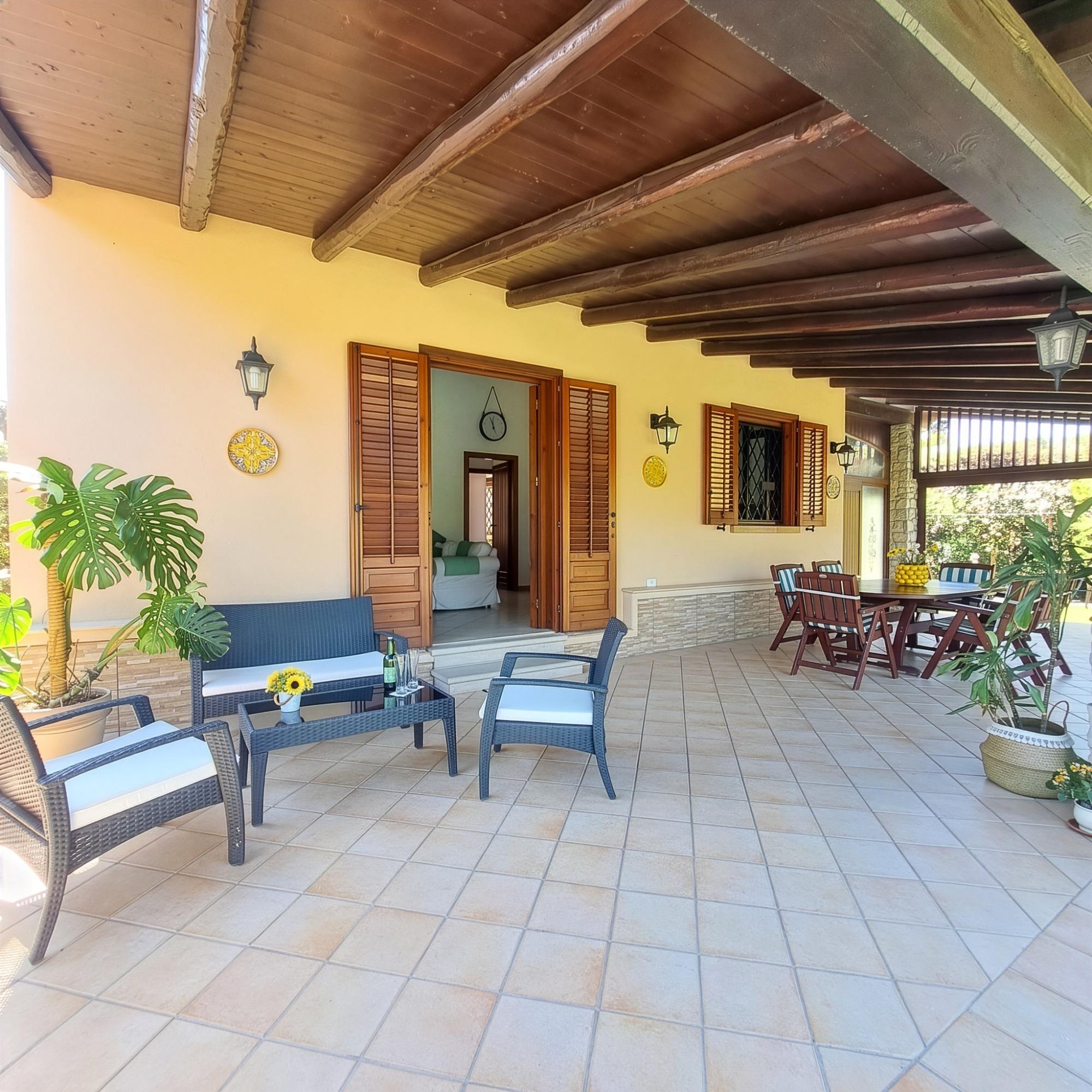 Vista veranda con tavolo da pranzo e salottino